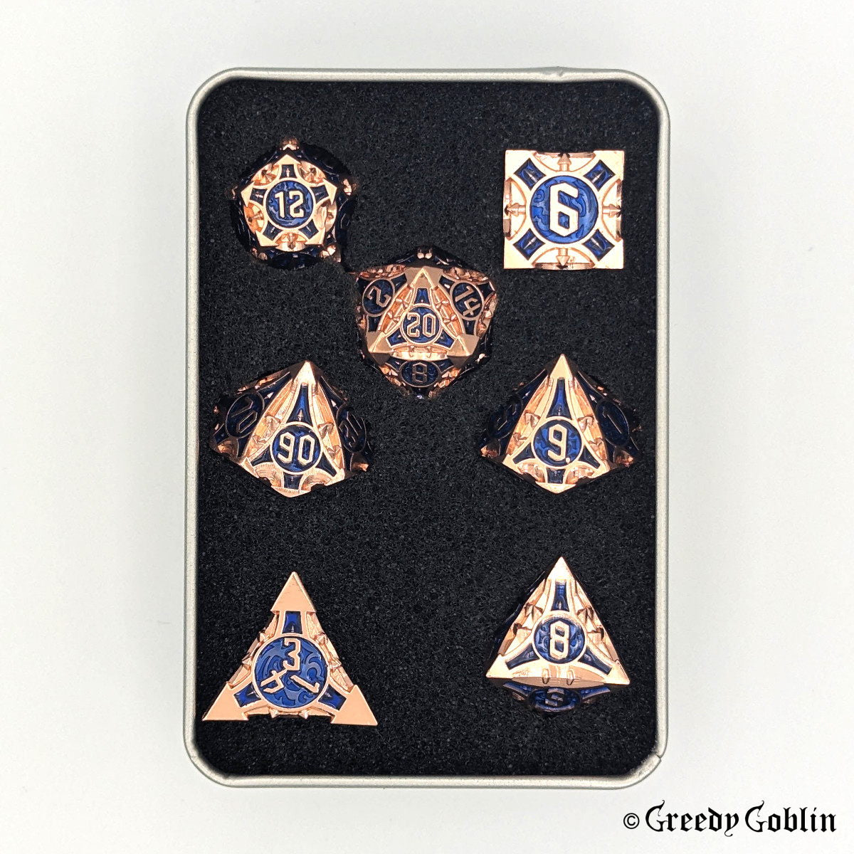 Copper metal Polydice set (D100, D8, D12, D10, D6, D20, D4) with blue engravings behind the numbers, in a metal tin box.