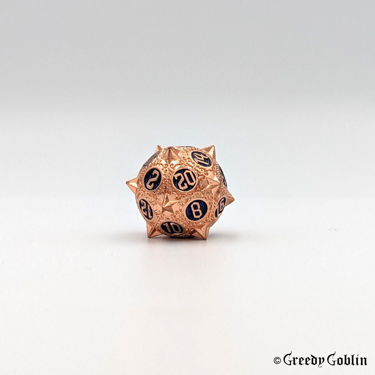 Metal D20 from DnD dice set with sharp edges and copper finish. The engravings behind the numbers are deep blue.