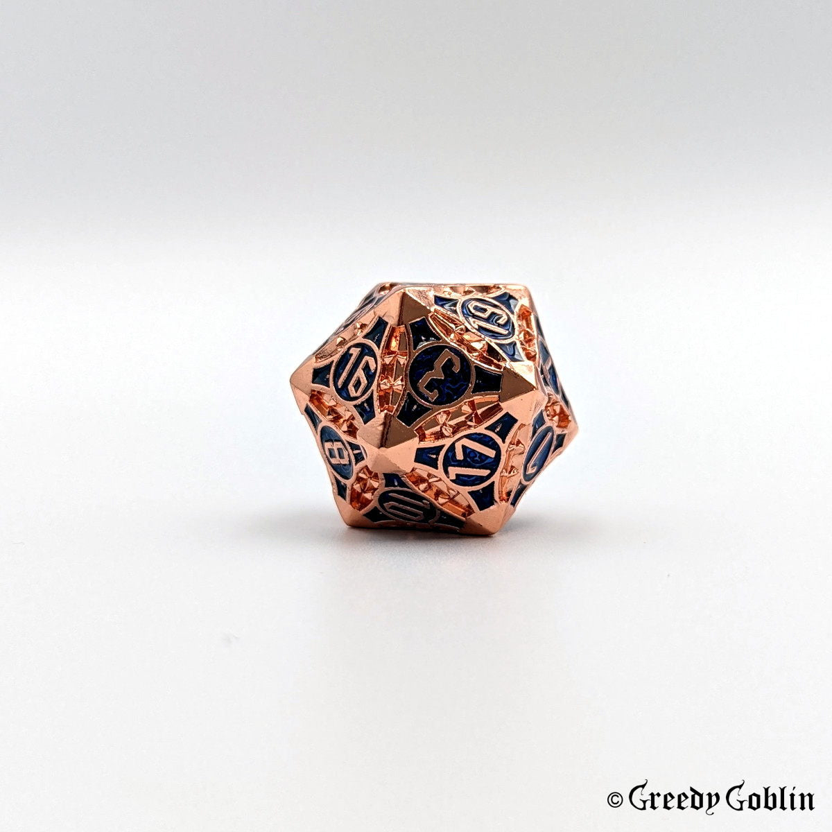 Copper metal D20 with blue engravings behind the numbers from Polydice set.