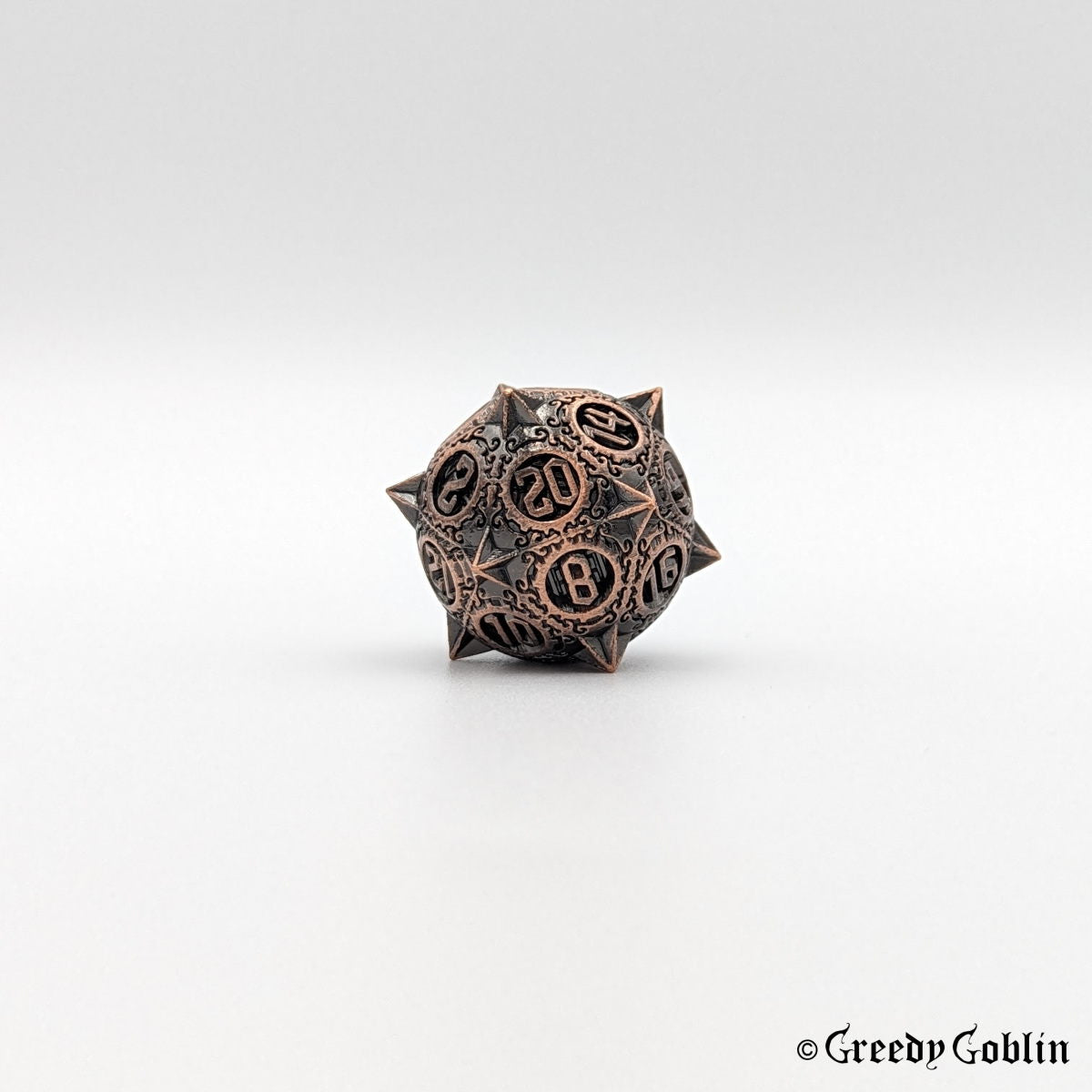 Metal D20 from DnD dice set with sharp edges and copper finish.