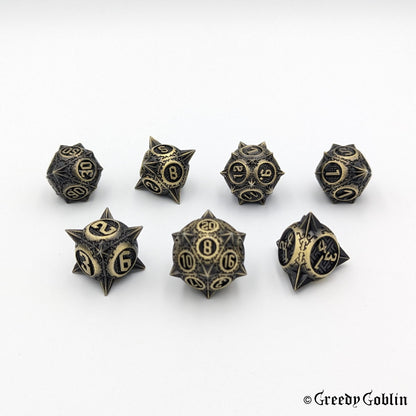 Metal DnD dice set (D4, D6, D8, D12, D20, 2x D10) with sharp edges and bronze finish.