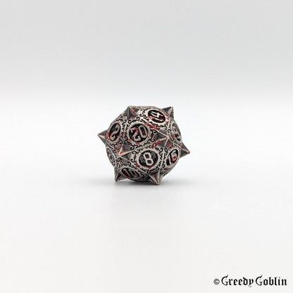 Metal D20 with sharp edges and red splatters from DnD dice set.