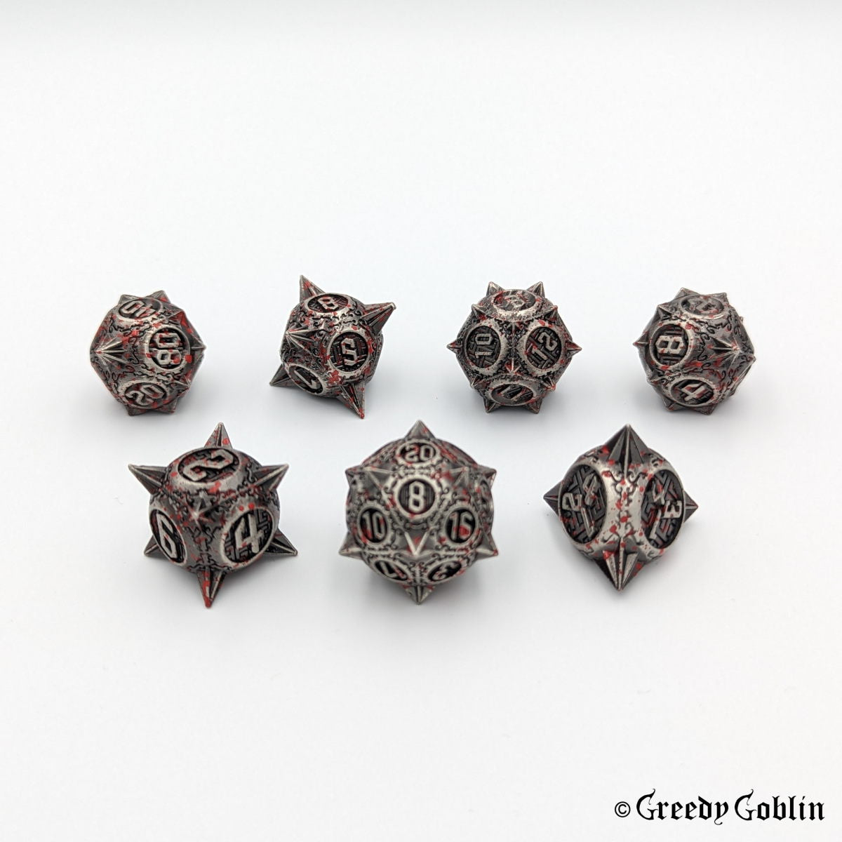 Metal DnD dice set (D4, D6, D8, D12, D20, 2x D10) with sharp edges and red splatters.