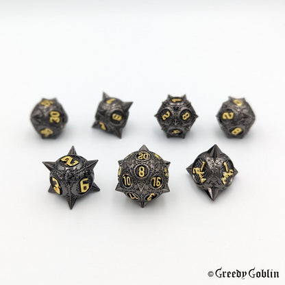 Gunmetal DnD dice set (D4, D6, D8, D12, D20, 2x D10) with sharp edges and gold numbers.