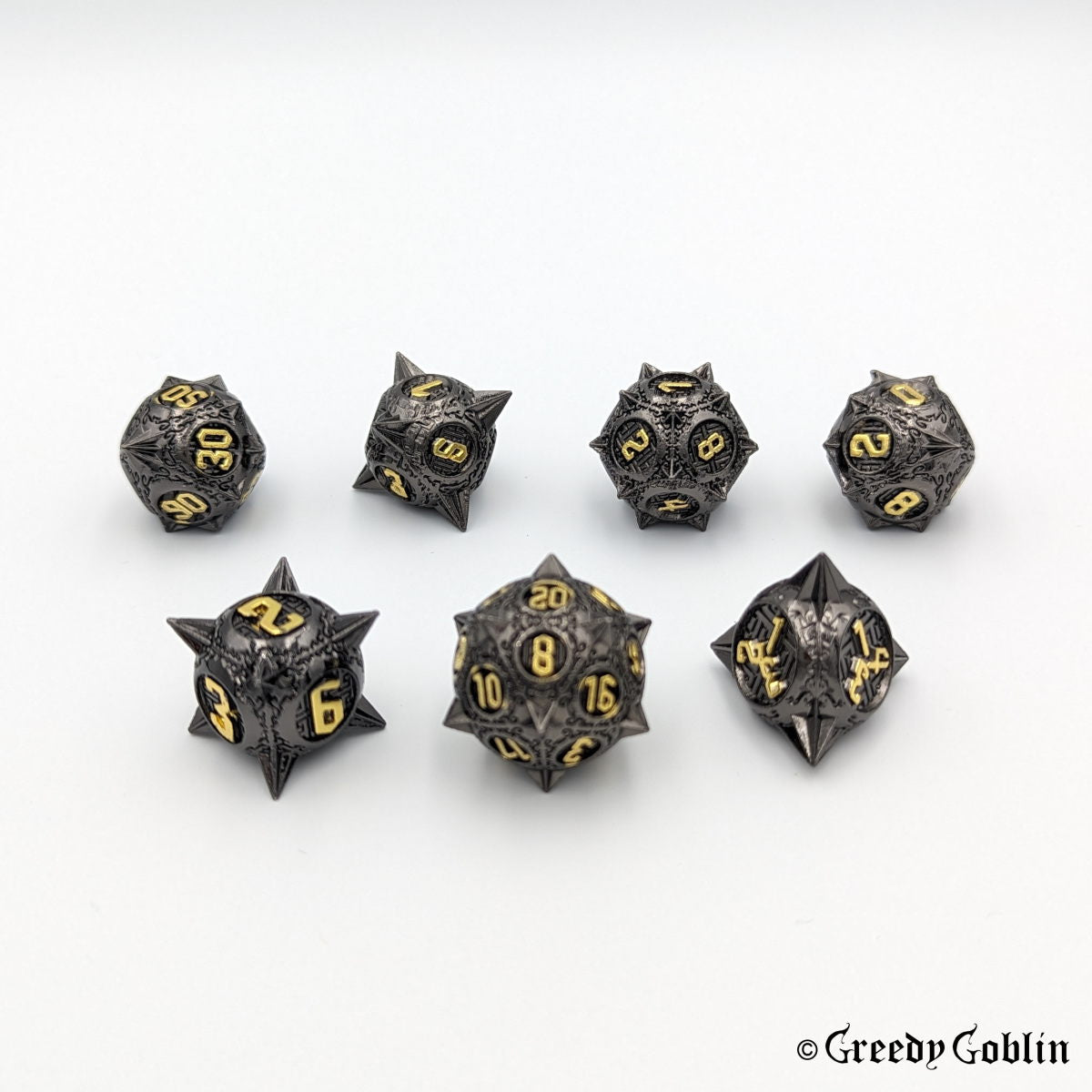 Gunmetal DnD dice set (D4, D6, D8, D12, D20, 2x D10) with sharp edges and gold numbers.