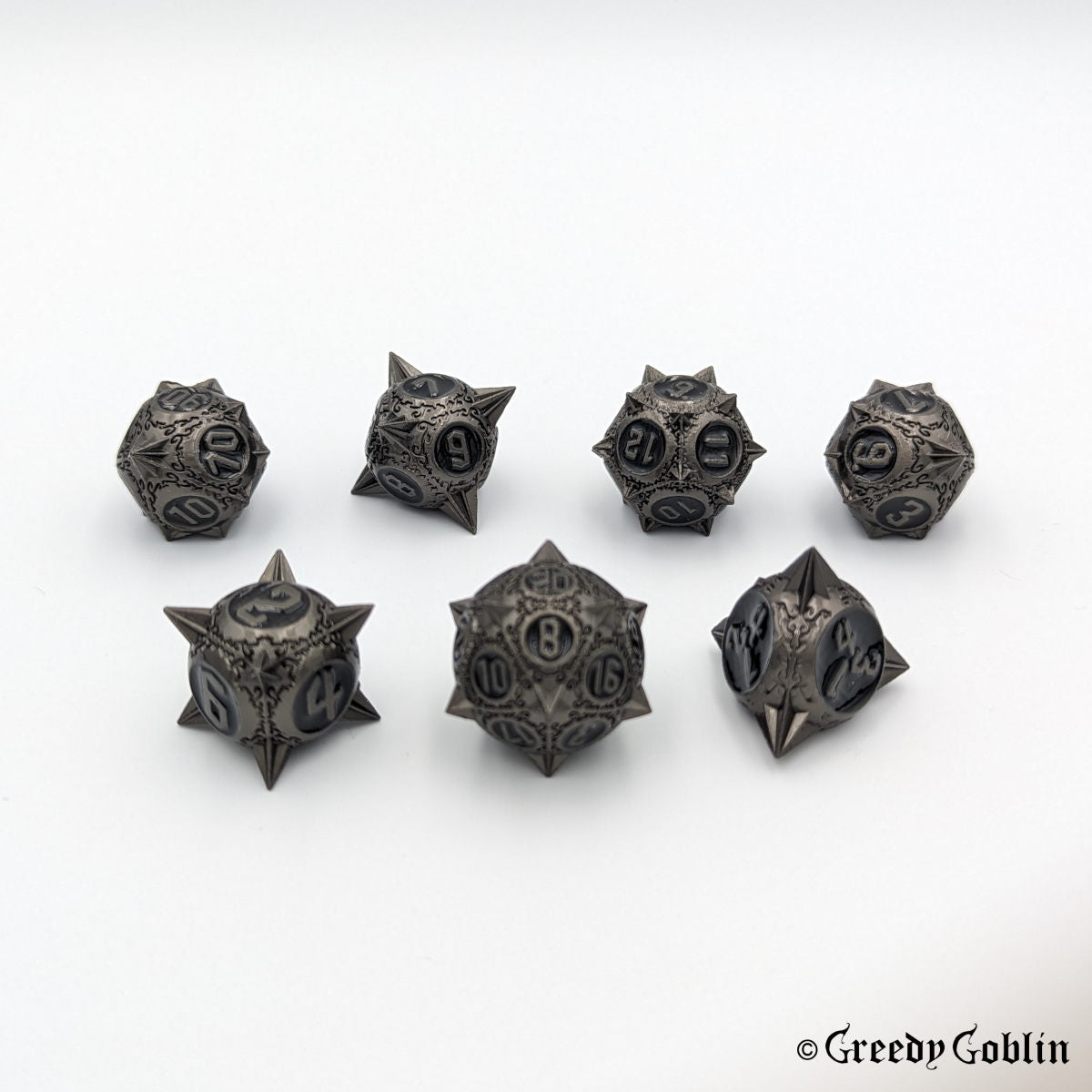 Metal DnD dice set (D4, D6, D8, D12, D20, 2x D10) with sharp edges and gunmetal finish. 