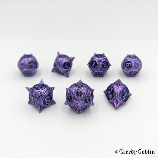 Metal DnD dice set (D4, D6, D8, D12, D20, 2x D10) with sharp edges and purple finish. The engravings behind the numbers are blue.