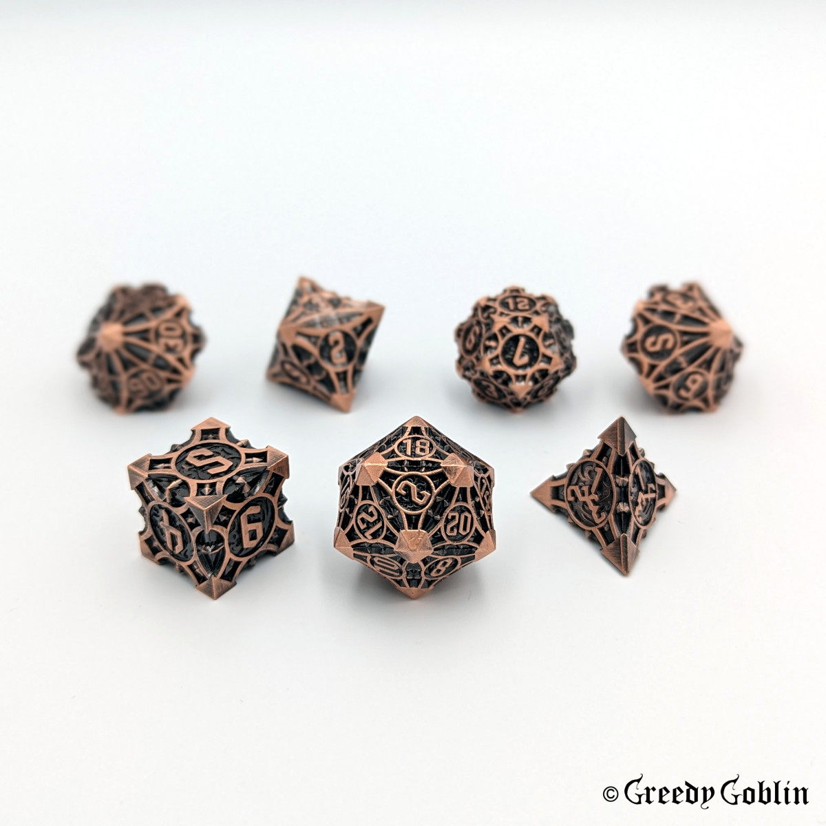 Copper metal Polydice set (D100, D8, D12, D10, D6, D20, D4) with black engravings.